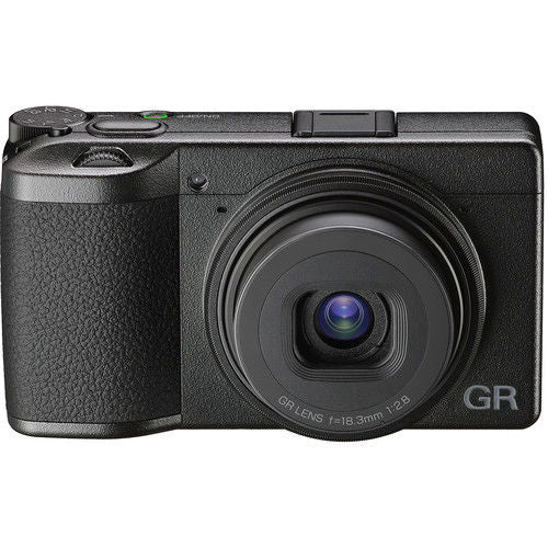 Black compact camera angled front view, prominent lens with visible lens markings