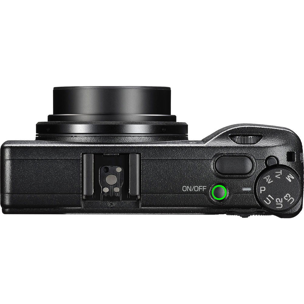 Black compact camera side view with buttons, green power light, and mode dial