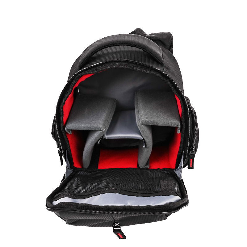 Front view of open black camera backpack showing red interior padding and zip compartments.