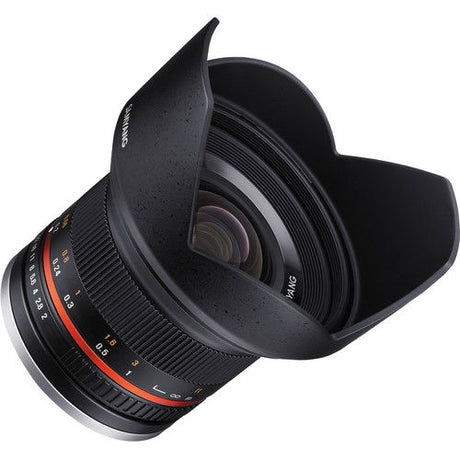 Black lens from side angle, hood open, visible focus and aperture rings, lens glass