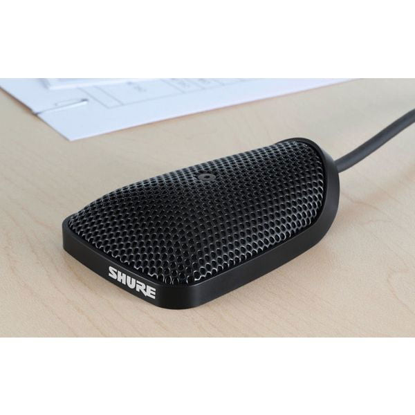 Black conference tabletop microphone on desk with connected cable and mesh grille