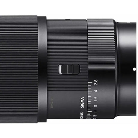 Close-up of black textured focus ring and aperture scale window on lens body