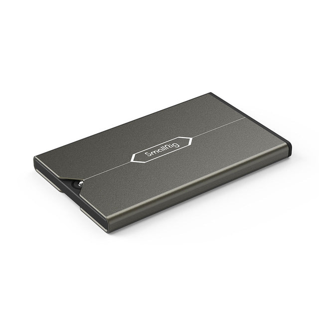 Compact gray memory card case with hinged lid, closed, logo on top