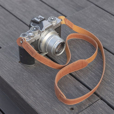 Brown leather camera strap with metal rings, curved end loops
