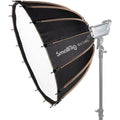 Parabolic softbox with black fabric and white interior, mounted on a studio light