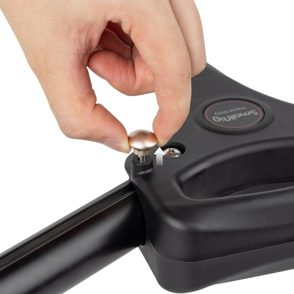 Hand tightening the adjustment knob on a black universal camera dolly