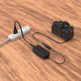 Dummy battery power adapter connected to camera and wall outlet via cables