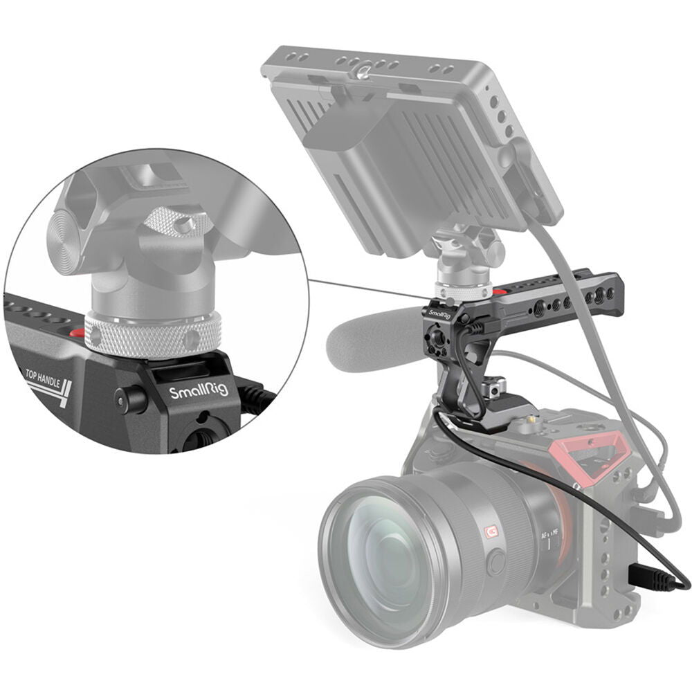 NATO top handle on camera rig with connected cables; red button and mounting holes
