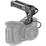 NATO top handle mounted on camera rig, red button and mounting holes, dark metal