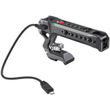 NATO top handle with red button; side ports and cable connector, dark metal body