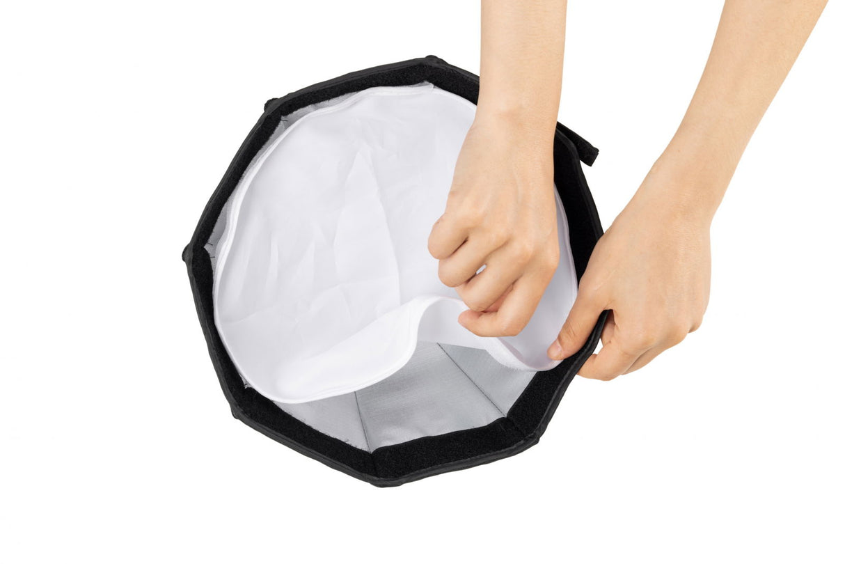 RA-D30 mini parabolic softbox with white diffusion fabric held open by hands