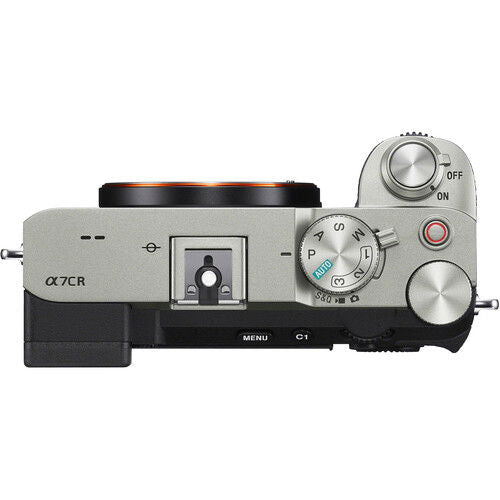 Mirrorless camera side view, silver top with mode dial and shutter/controls