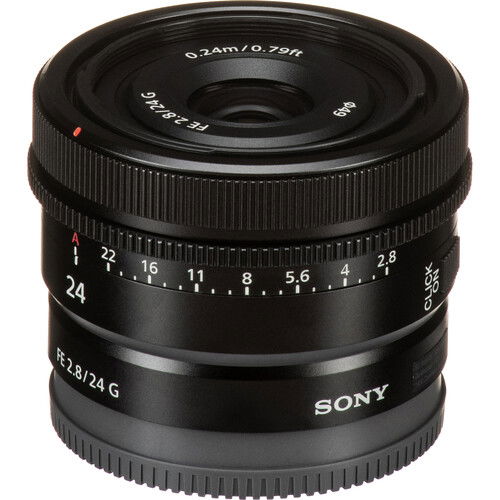 Black 24mm lens angled view showing front glass, distance marks, and ribbed focus ring