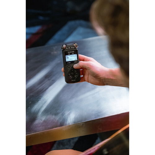 Portable audio recorder in hand with LCD screen and record controls
