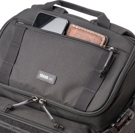 Black backpack front pocket with zipper, organizer panel, and small logo patch