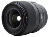 FiRIN 20mm f/2 FE AF lens, angled view showing front glass and ridged focus ring
