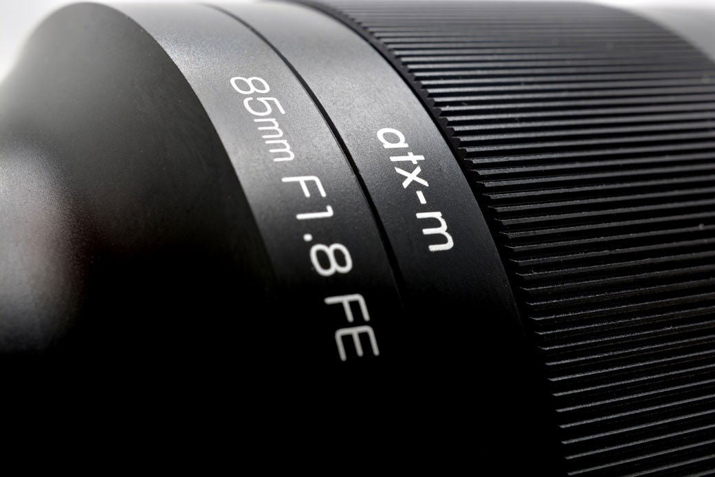 Engraved 85mm and F1.8 labels on atx-m lens barrel with textured focus ring