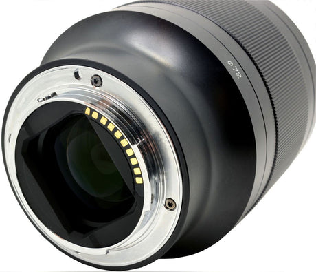 Front close-up of atx-m 85mm F1.8 FE lens showing glass element and yellow indicator dots
