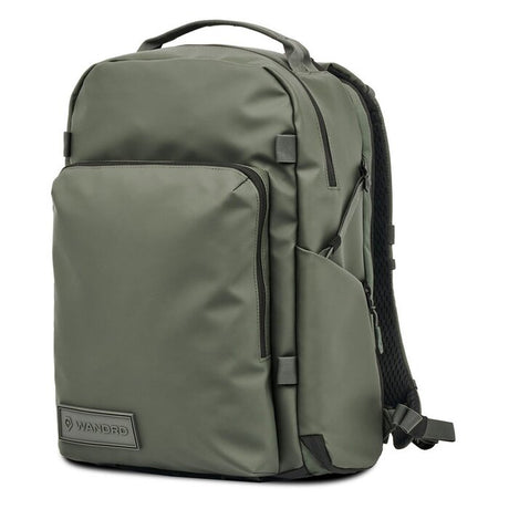 Rucsac foto Wasatch Green WANDRD, față cu buzunar cu fermoar și bretele laterale.