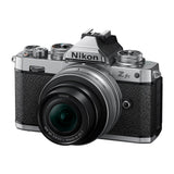 Silver mirrorless camera with black textured grip and attached zoom lens