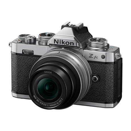 Silver mirrorless camera with black textured grip and attached zoom lens