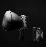 Bi-color LED light on stand with reflector; compact LED panel shown beside it